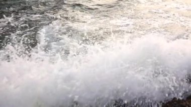 Dalgalar deniz formunun taşlı kıyıya sprey ve köpük yendi. Ağır çekim