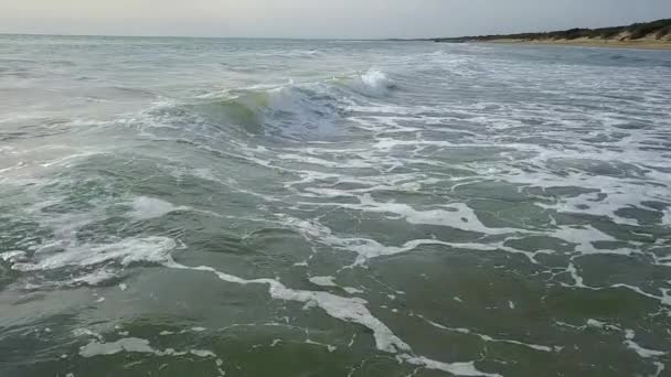 Vue sur les vagues de près, puis de la hauteur sortante à l'horizon de la mer. Relevé aérien. Mouvement lent 