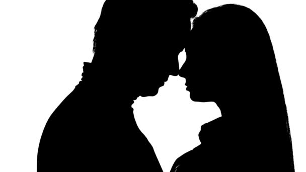 Kissing couple in the studio is worth it. Silhouette. White background. Close up — Stock Video