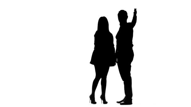 Couple in love is waiting for friends and waving at them. Silhouette. White background — Stock Video