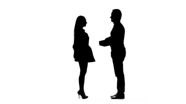Mann schenkt seinem geliebten Mädchen ein Geschenk. Silhouette. weißer Hintergrund — Stockvideo