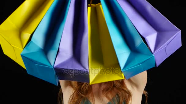 Girl with the packages in her hands is happy. Black background — Stock Video