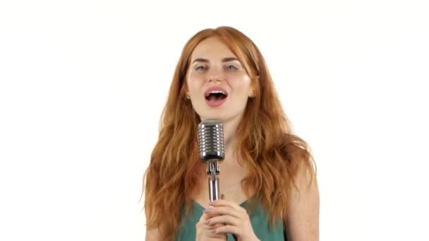 Girl with freckles sings in a retro microphone. White background — Stock Video