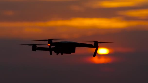 Copter flies, in the background a crimson sunset, he flies away — Stok Video