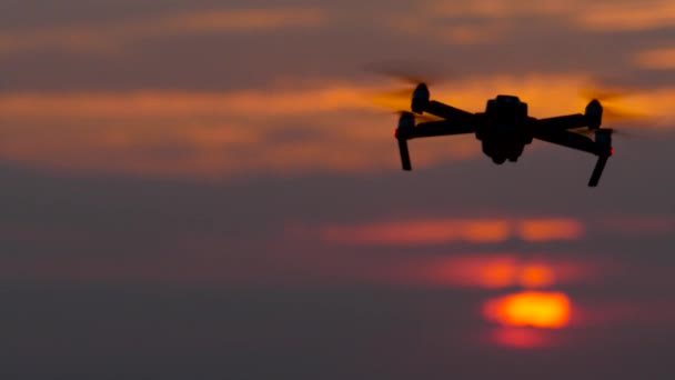 Dron obraca się wokół własnej osi na tle zachodzącego słońca — Wideo stockowe