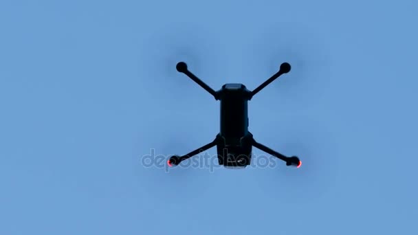 Dron létá daleko proti modré obloze. Pohled zdola — Stock video