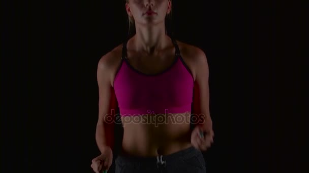 Meisje fitness loopt gestaag op een zwarte achtergrond. Slow-motion. Close-up — Stockvideo