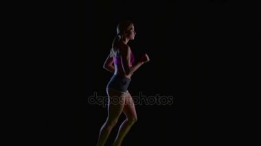 Kadın incelikle yan görünüm siyah arka plan üzerinde çalışır. Ağır çekim