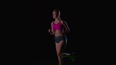 Spor kız çalıştırıyor. Önden Görünüm. Siyah ekran. Ağır çekim