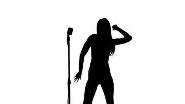 Kadın şarkı şarkı ve dans etmek bir retro mikrofon yakınındaki. Siluet. Beyaz arka plan