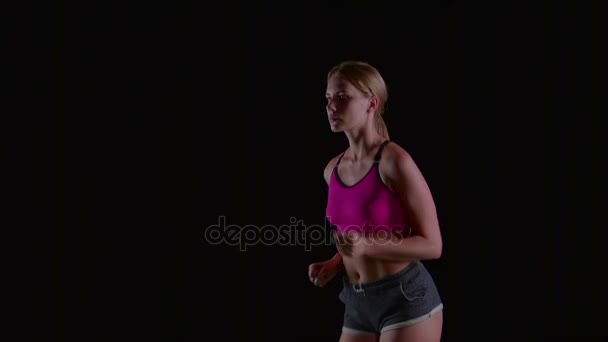 Atleet in de sport kleren die licht op een zwart scherm worden uitgevoerd. Slow-motion. Close-up — Stockvideo