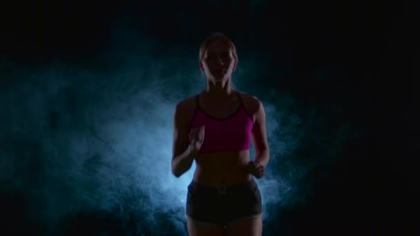 Sport meisje uitvoeren Vooraanzicht. Zwart scherm in de rook. Silhouet. Slow-motion. Close-up — Stockvideo