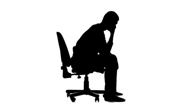 Adam bir sandalyeye oturur ve düşünüyor, yansıtır ideashe üzücü. Siluet. Beyaz arka plan — Stok video