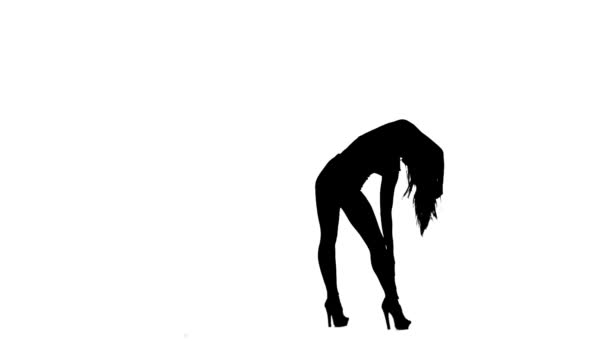 Fashion model is sexually wriggling her body. Silhouette. White background. Slow motion — Stock Video