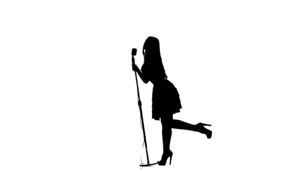 Woman sing song and dances near a retro microphone. Silhouette. White background. Slow motion — Stock Video