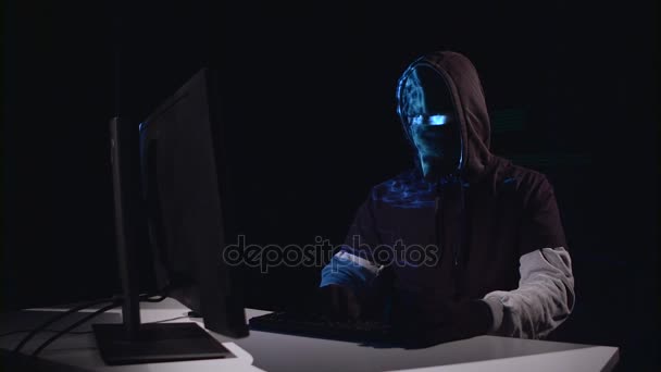Terrorista hackear computador sentado em uma sala escura. Fundo preto — Vídeo de Stock