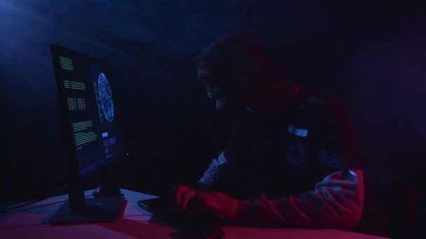 Man copies information from the computer, on the table is a gun. Black smoke background — Stock Video