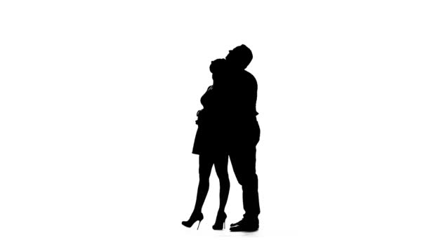 Liebevolle Paarküsse und Tänze zusammen. Silhouette. weißer Hintergrund. Zeitlupe — Stockvideo