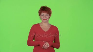 Redhaired kadın ürünleri tanıtır ve baş parmak işareti gösterir. Yeşil ekran