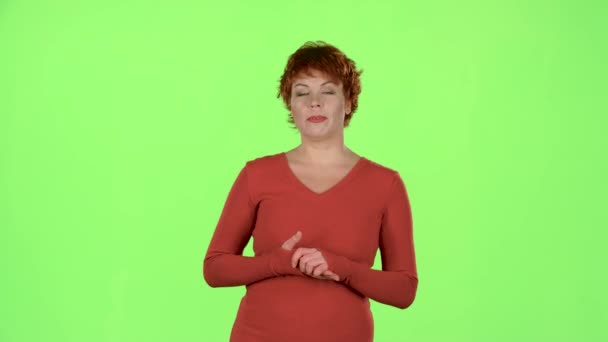Rödhårig kvinna talar om proffsen på varorna. Grön skärm — Stockvideo