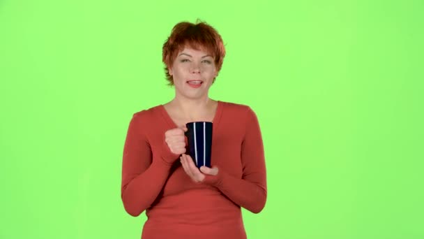 Frau mit einer Tasse Tee blickt in die Ferne und denkt über ihre eigenen Angelegenheiten nach. Green Screen — Stockvideo