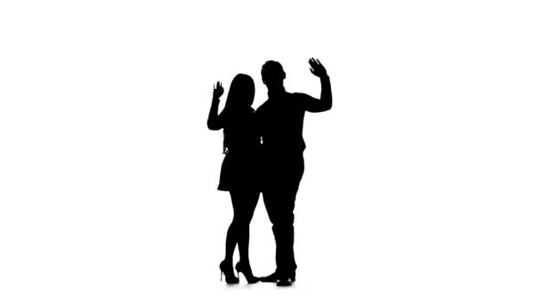 Couple in love is waiting for friends and waving at them. Silhouette. White background. Slow motion — Stock Video