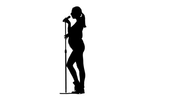 La chica canta en el karaoke, está embarazada. Silueta. Fondo blanco. Movimiento lento — Vídeo de stock