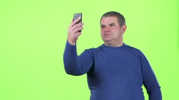 Man gör selfie på sin smartphone. Grön skärm. Slow motion — Stockvideo