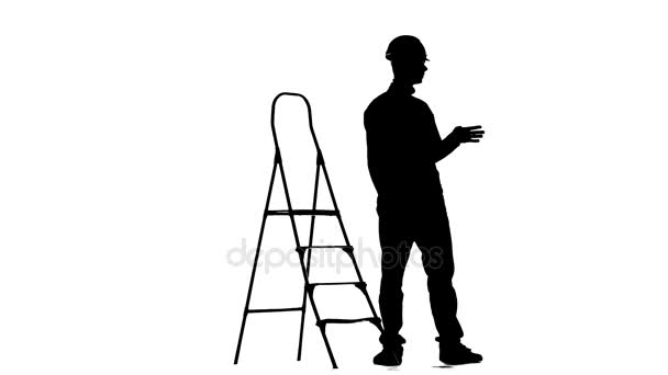 Brigadier in a helmet stands near the stepladder. Silhouette. White background — Stock Video