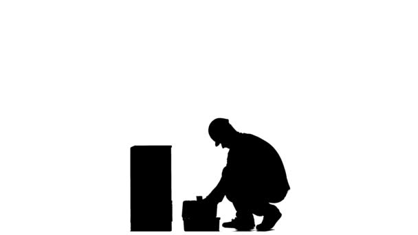 Builder in a helmet hammers a nail with a hammer. Silhouette. White background — Stock Video