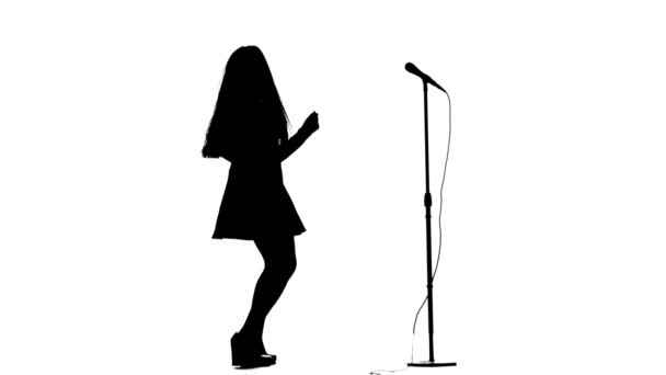 Aktorka w retro mikrofon śpiewa piosenkę rockową. Białe tło. Sylwetka. Widok z boku — Wideo stockowe