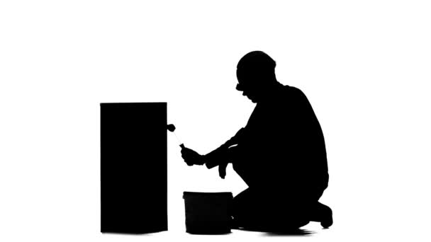 Trabajador en un casco pinta un edificio con un rodillo. Silueta. Fondo blanco — Vídeos de Stock