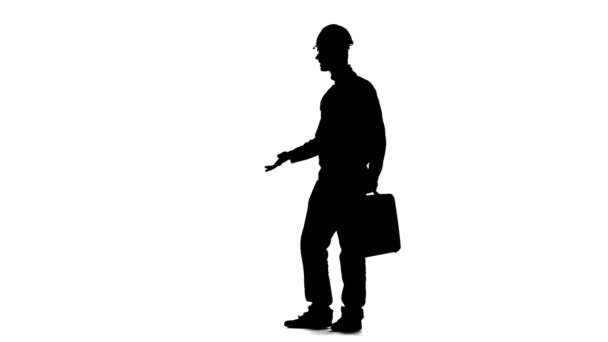 Builder with a diplomat in his hands and a helmet on his head. Silhouette. White background. Slow motion — Stock Video