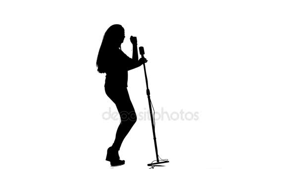Vocalista interpreta canciones incendiarias en un micrófono. Fondo blanco. Silueta. Movimiento lento — Vídeos de Stock
