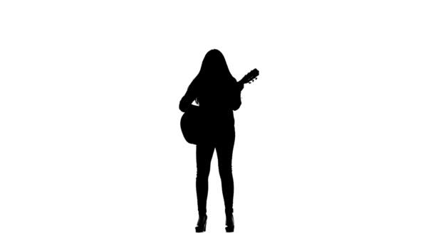 Zangeres speelt gitaar en zingt. Witte achtergrond. Silhouet. Slow motion — Stockvideo