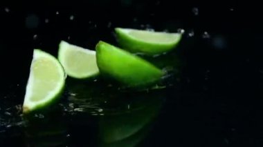 Kireç masanın üzerine düşüyor ve parçalara böler. Siyah arka plan. Ağır çekim