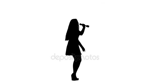 Співачка в сукні співає пісні в мікрофон. Білий фон. Силует. Вид збоку. Повільний рух — стокове відео