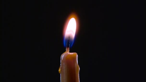 Ruka s zapalovač zapálí Jedna svíčka. Černé pozadí. Detailní záběr