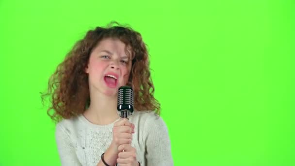 Κοριτσάκι τραγουδάει σε φλογερό τραγούδια ρετρό μικρόφωνο. Πράσινη οθόνη — Αρχείο Βίντεο