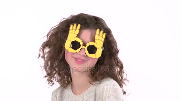 Niña bailando con gafas graciosas. Fondo blanco — Vídeos de Stock