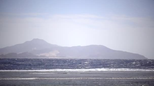 Океан бушует от ветра, волны бьются о берег — стоковое видео