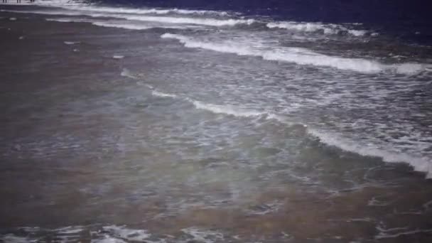 Голубой океан бушует от ветра, волны бьются о берег — стоковое видео