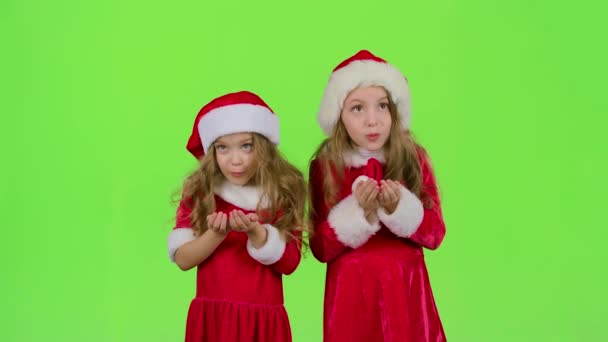 Crianças meninas nos trajes de Natal inflar o pólen estelar. Tela verde. Movimento lento — Vídeo de Stock