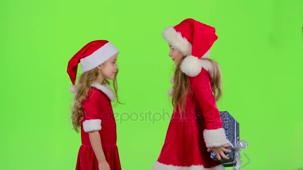 Ребенок дарит новогодний подарок своей подруге. Зеленый экран. Медленное движение — стоковое видео
