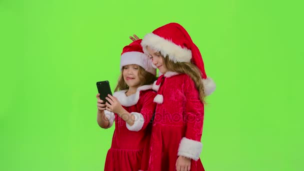 Las niñas con disfraces de Año Nuevo hacen selfies por teléfono. Pantalla verde — Vídeos de Stock