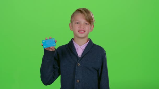 Tonåring visar och vänder huvudet till kreditkortet på en grön skärm — Stockvideo