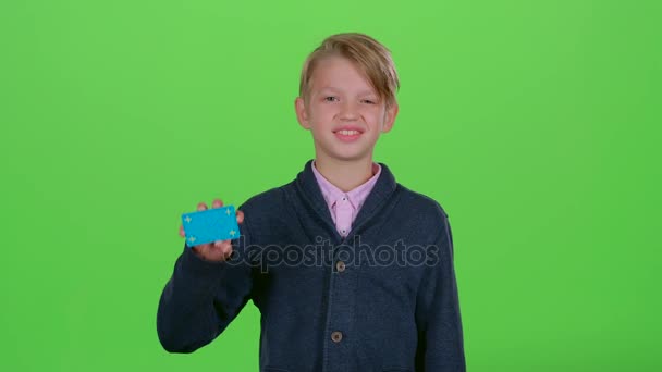 Хлопчик з кредитною карткою показує, як на зеленому екрані — стокове відео
