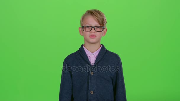 Bambino ragazzo con gli occhiali guardato la carta di credito e ha mostrato antipatia su uno schermo verde — Video Stock