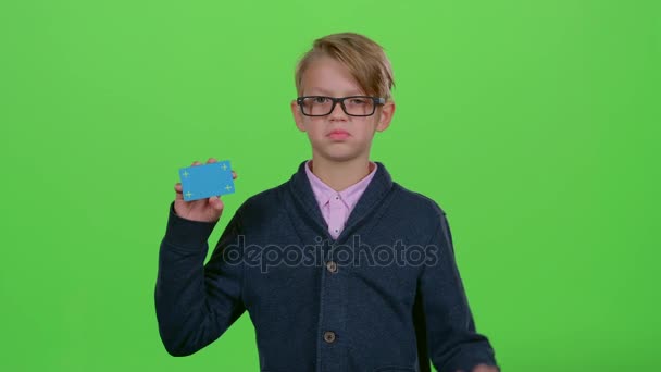 Menino de óculos com cartão de crédito mostra antipatia e, em seguida, como em uma tela verde — Vídeo de Stock