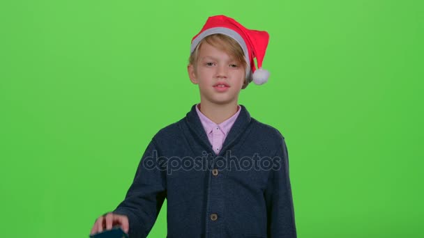 Adolescente en el sombrero de año nuevo con una tarjeta de crédito muestra como en una pantalla verde — Vídeo de stock